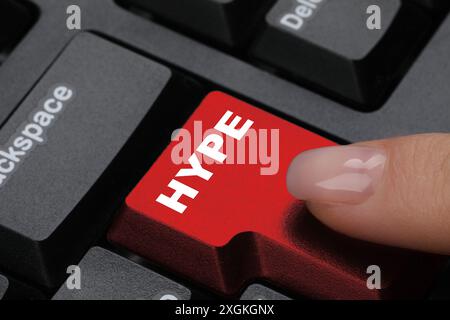Woman pressing Hype button on computer keyboard, closeup Stock Photo
