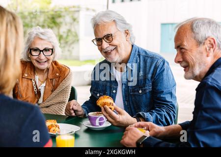 Elderly people enjoying breakfast in the morning at cafeteria bar. Stock Photo