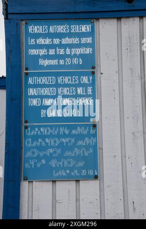 Multilingual authorized vehicles parking only sign in English, French and Inuktitut in Iqaluit, Nunavut, Canada Stock Photo