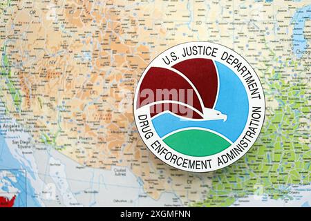 KYIV, UKRAINE - JUNE 26, 2024 U.S. Justice Department Drug Enforcement Administration coat of arms on paper map of United States of America Stock Photo