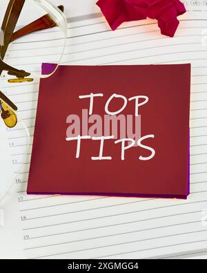 top tips word. text concept symbol TOP TIPS on a red sticker on the background of a sheet in a ruler Stock Photo