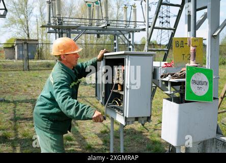 At the power substation. Worker checking connections on the electric board. Pump station. May 5, 2018. Oseschina, Ukraine Stock Photo