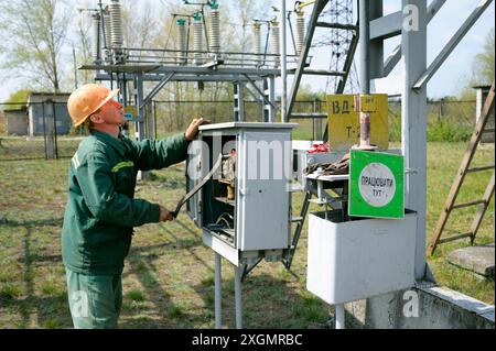 At the power substation. Worker checking connections on the electric board. Pump station. May 5, 2018. Oseschina, Ukraine Stock Photo