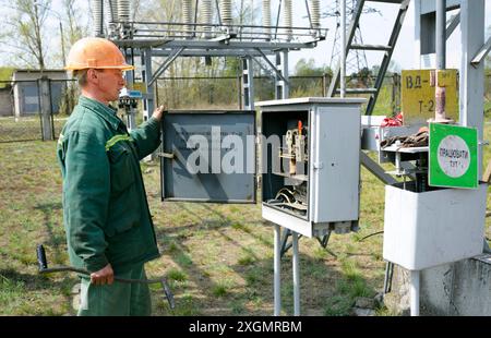 At the power substation. Worker checking connections on the electric board. Pump station. May 5, 2018. Oseschina, Ukraine Stock Photo