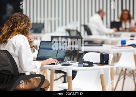 Professional business woman working on a coworking area. Corporate employee Stock Photo