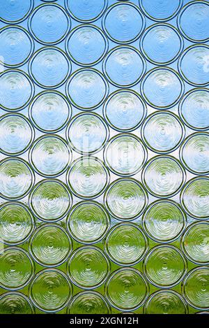 View through an opaque pane of glass, window pane, with green meadow and blue sky Stock Photo