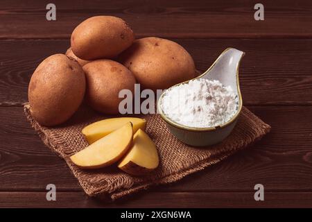 Potato starch, on a wooden table, close-up, rustic style, no people, potatoes, ceramic spoon, saucepan, wooden table, brown Stock Photo