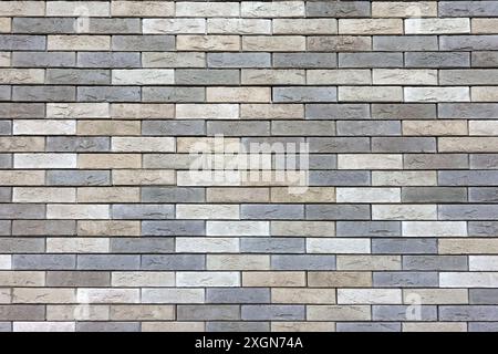 Wall from motley beige decorative spotted bricks horizontal photo front view close up Stock Photo