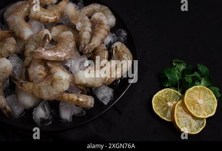Frozen raw shrimp vannamey, on wooden skewers, ice cubes and lime slices, top view, no people Stock Photo