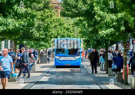 Bus driving down a tree lined Fishergate in Preston city centre Stock Photo