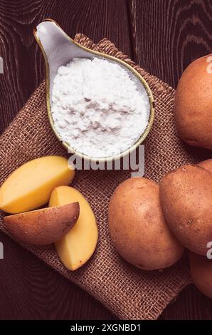 Potato starch, on a wooden table, close-up, rustic style, no people, potatoes, ceramic spoon, saucepan, wooden table, brown Stock Photo