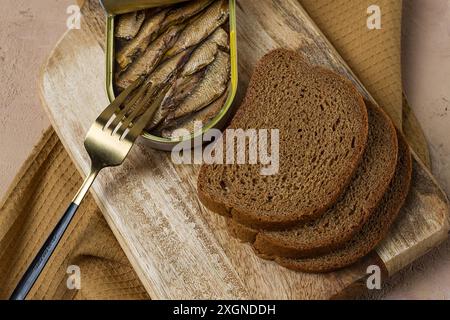 Sprats in butter, with black bread, canned smoked fish, open, close-up, top view, no people Stock Photo