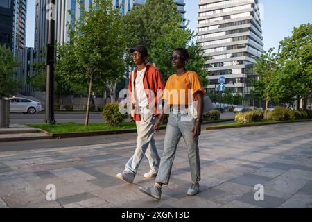 Unpleased thoughtful African-American couple in love ignore each other over quarrel walking in city. Stock Photo