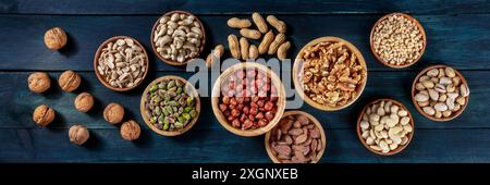 Nuts panorama. Walnuts and cashews, peanuts, and hazelnuts, almonds, pine nuts and pistachios, overhead flat lay shot Stock Photo