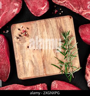 Many beef cuts, shot from above around a wooden cutting board, forming a frame for copy space Stock Photo