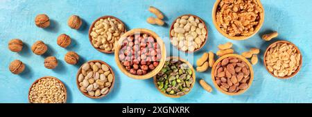 Nuts panorama on a vibrant blue background. A selection of various nuts, shot from above Stock Photo