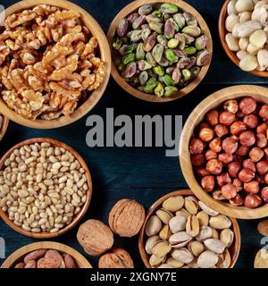 Nuts variety square design template. Various nuts in wooden bowls, overhead flat lay shot with copy space Stock Photo