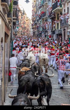 Pamplona, Spain. 10th July, 2024. Several runners run in front of the bulls from the Fuente Ymbro ranch through the streets of Pamplona during the San Fermín 2024 festivities. (Photo by Fernando Pidal/SOPA Images/Sipa USA) Credit: Sipa USA/Alamy Live News Stock Photo