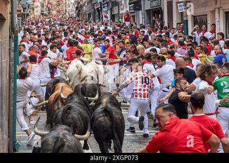 Pamplona, Spain. 10th July, 2024. Several runners run in front of the bulls from the Fuente Ymbro ranch through the streets of Pamplona during the San Fermín 2024 festivities. (Photo by Fernando Pidal/SOPA Images/Sipa USA) Credit: Sipa USA/Alamy Live News Stock Photo