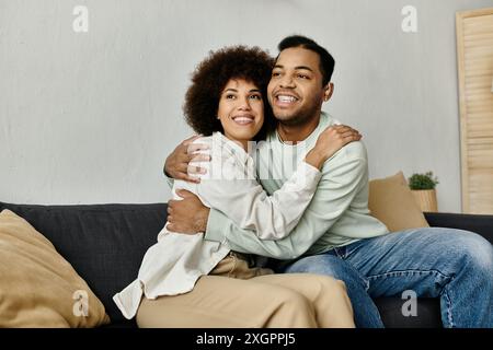 An African American couple communicates using sign language while sitting on a couch. Stock Photo