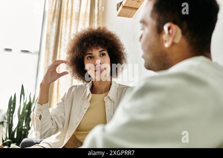 An African American couple using sign language to communicate in their living room. Stock Photo