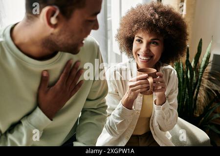 An African American couple communicates using sign language while enjoying a cozy moment at home. Stock Photo