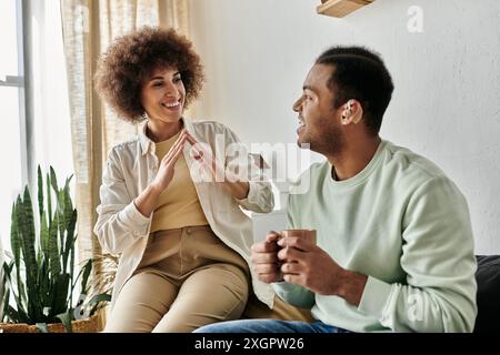 A happy African American couple communicates through sign language at home. Stock Photo