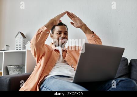 An African American man signing while using a laptop. Stock Photo