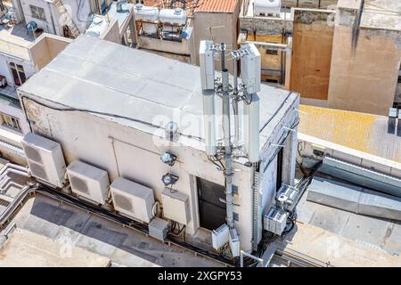 Building with a rooftop antenna and a lot of wires. Modern city rooftop with air conditioners and antennas Stock Photo