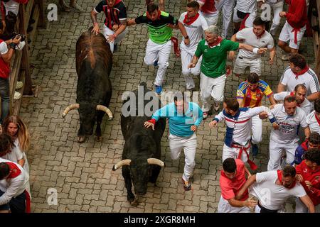 Pamplona, Spain. 10th July, 2024. Several young men run in front of the bulls during the running of the bulls at the San Fermín 2024 festivities. The Fuente Ymbro cattle ranch has starred in the fourth running of the bulls of San Fermín 2024 in Pamplona. It was an immaculate and fast race. Credit: SOPA Images Limited/Alamy Live News Stock Photo