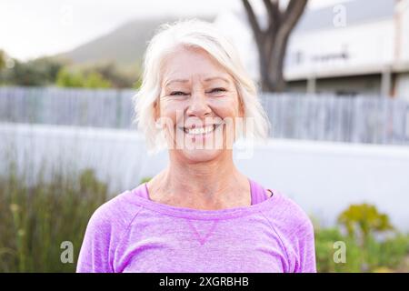Portrait of happy senior caucasian woman with white hair smiling outdoors. Wellbeing, health and active senior lifestyle, unaltered. Stock Photo