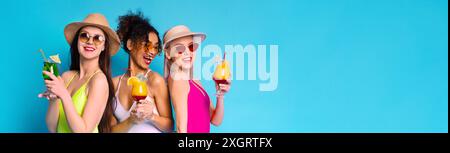 Three Happy Women In Swimsuits Enjoying Cocktails On Blue Background Stock Photo