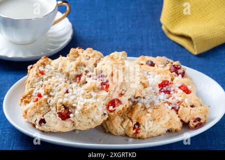 Two fresh traditional large, English, Cherry Rock cakes served with a cup of black coffee. The cakes are plated on a plain table cloth Stock Photo