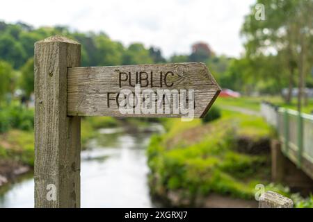 Close up of a traditional, wooden sign, marker indicating a PUBLIC FOOTPATH in the UK countryside (pointing to the right). Stock Photo