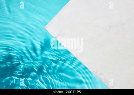 Poolside Calm. A serene image showcasing a clean pool with crystal blue water and a white poolside. Stock Photo