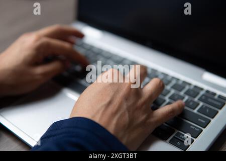 A close-up image of a person's hands typing on a laptop keyboard. Productivity, busy and working concept. Stock Photo
