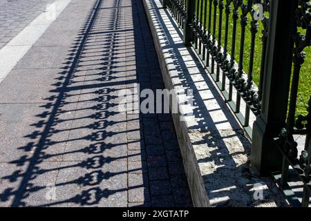 Pattern from shaped contrasting shadow from vintage fence. Stock Photo