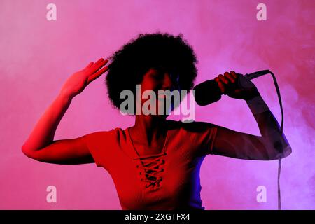 Singer with microphone in neon lights on stage Stock Photo