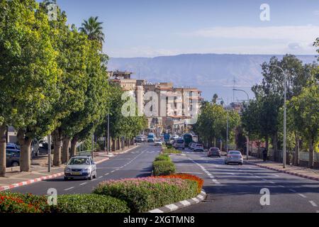 The scenic road going down to Sea of Galilee in Tiberias, Israel, with city panorama and Golan heights behind the lake. Stock Photo