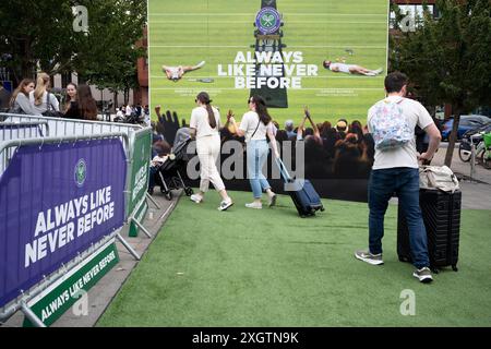 Members of the public and an ad hoarding at Wimbledon station in the second week of the All England Lawn Tennis Association's championship, on 9th July 2024, in London, England. Stock Photo