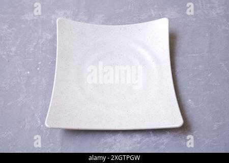 white plate for food with dotted pattern on the gray background Stock Photo