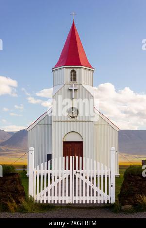 Small white church in green grass field with historical Icelandic turf houses Glaumbaer in Skagafjodur Landscape in summer season travel Stock Photo