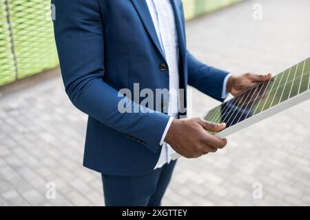 Cropped unrecognizable image of a Black businessman's hands analyzing a solar panel Stock Photo