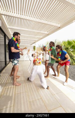 A diverse group of friends dances joyfully on a patio during a summertime gathering, showcasing a cheerful, multiethnic dynamic. Stock Photo