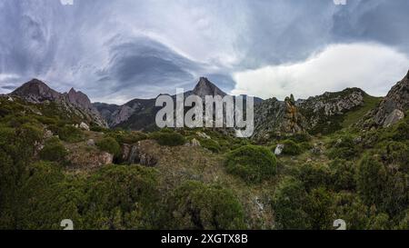 Panoramic view of a rugged mountain range under a dramatic, swirling cloud formation, exuding a sense of serene majesty and raw nature Stock Photo
