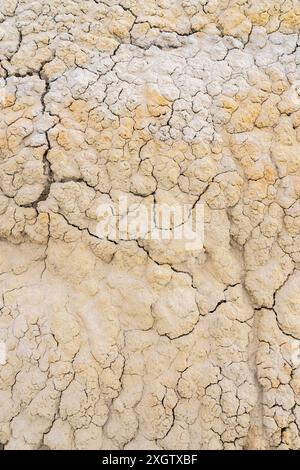 This image captures the intricate patterns of cracked sand textures in natural tones ranging from white to yellow, showcasing the unique beauty of des Stock Photo