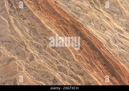 Close-up shot of a colorful, textured stone surface with naturally occurring patterns in a desert environment, highlighting the intricate details and Stock Photo