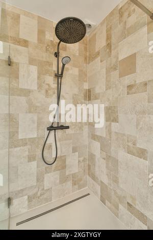A contemporary shower setup featuring a large, round, wall-mounted shower head with an adjustable handheld attachment set against a stylish backdrop o Stock Photo