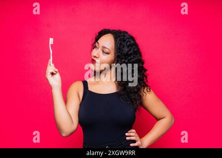 Pretty african lady with beautiful smile holding toothbrush and taking care of her teeth health Stock Photo