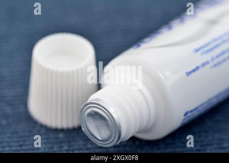 Sealed toothpaste tube Sensodyne Repair & Protect close up detail on blue Stock Photo